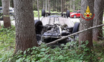 Perde il controllo dell'auto che finisce rovesciata in mezzo agli alberi